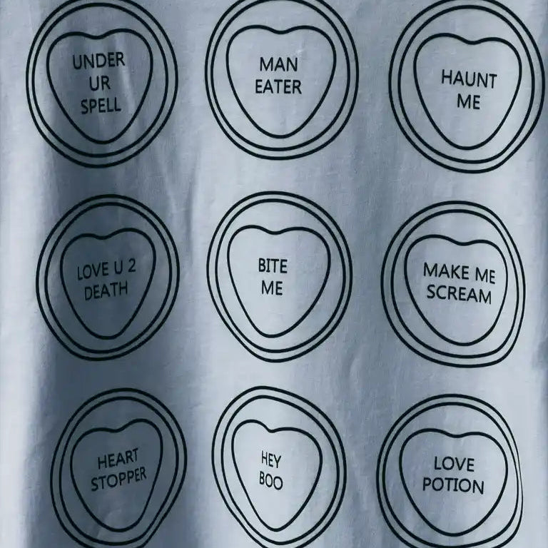 White t-shirt with black heart-shaped text designs on a plain background