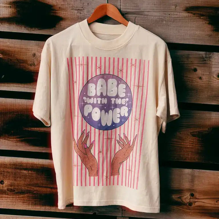 T-shirt with 'Babe with the Power' design on a wooden background