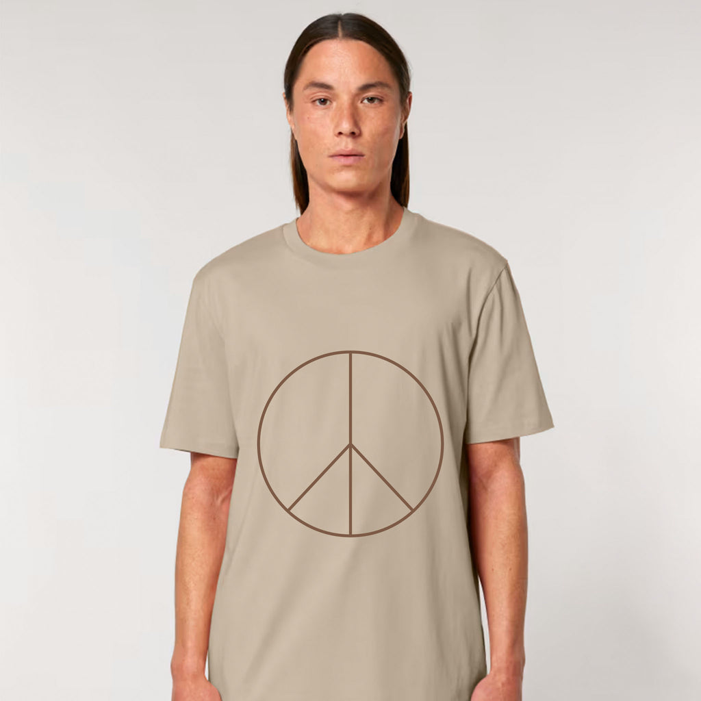 Person wearing a beige t-shirt with a peace symbol design on a plain background