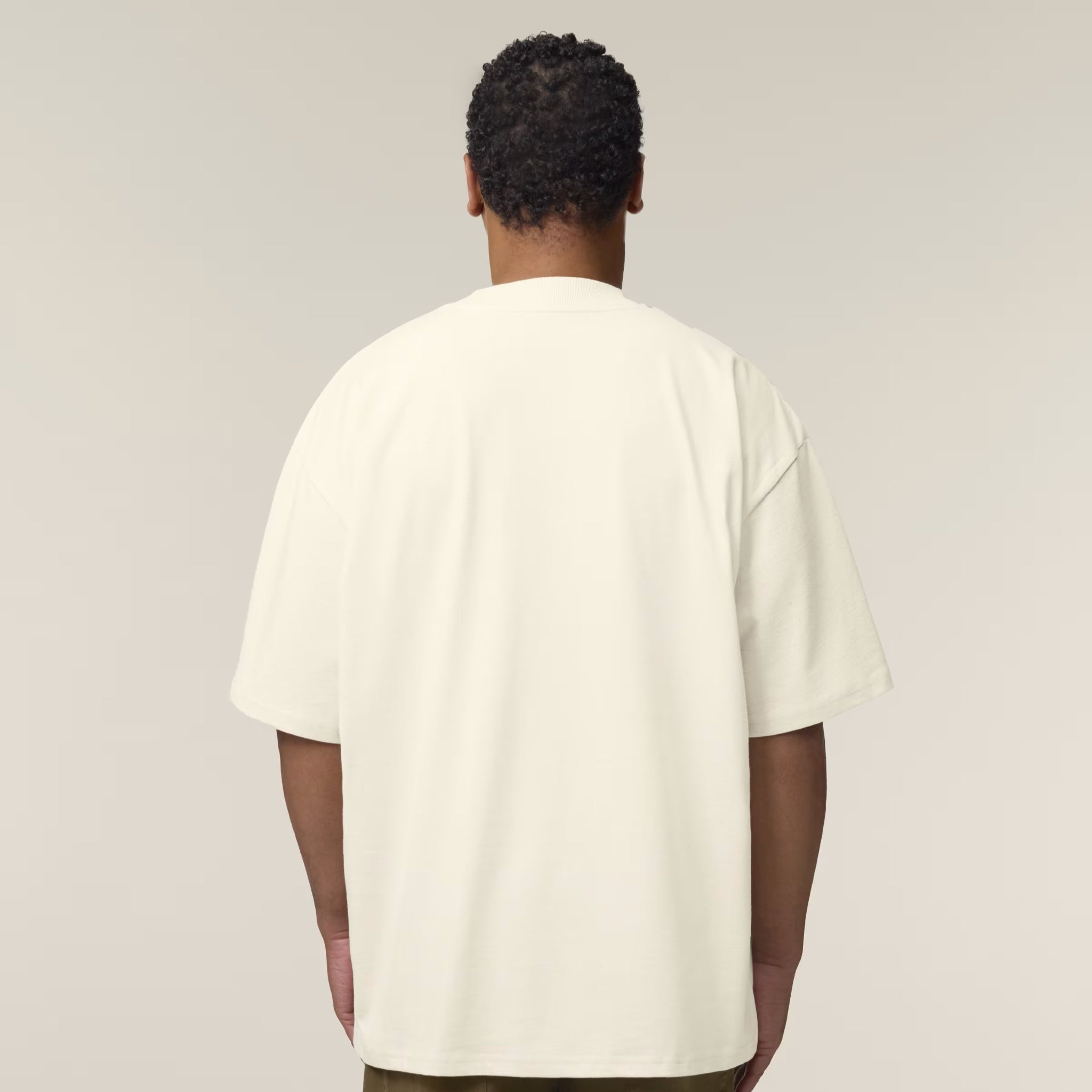 Person wearing a plain beige t-shirt against a neutral background