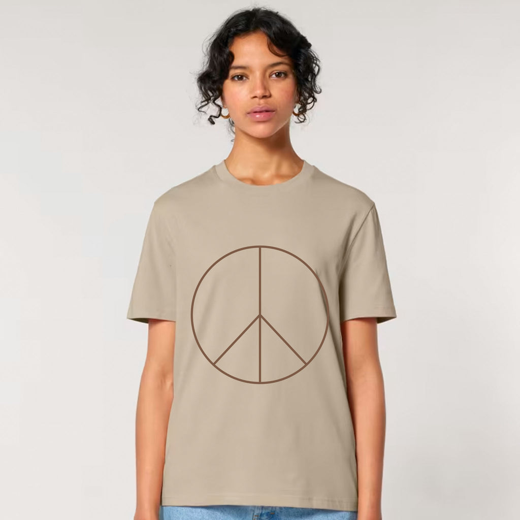 Person wearing a beige t-shirt with a peace symbol design on a plain background