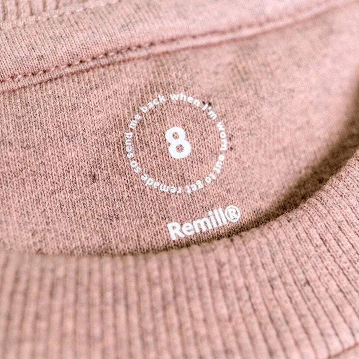 Close-up of a pink fabric with a brand logo and text.