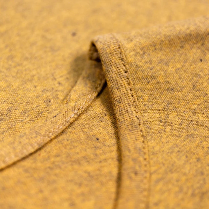 Close-up of textured mustard yellow fabric with a visible seam.