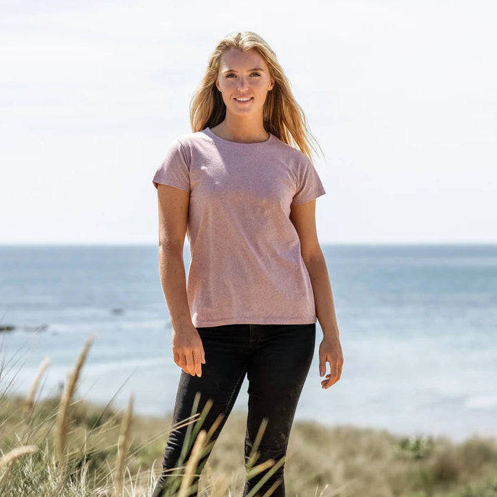 Woman standing on a beach with ocean in the background