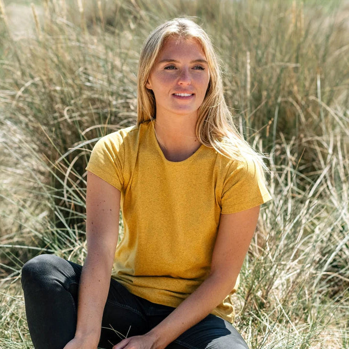 Woman in a yellow shirt sitting in tall grass