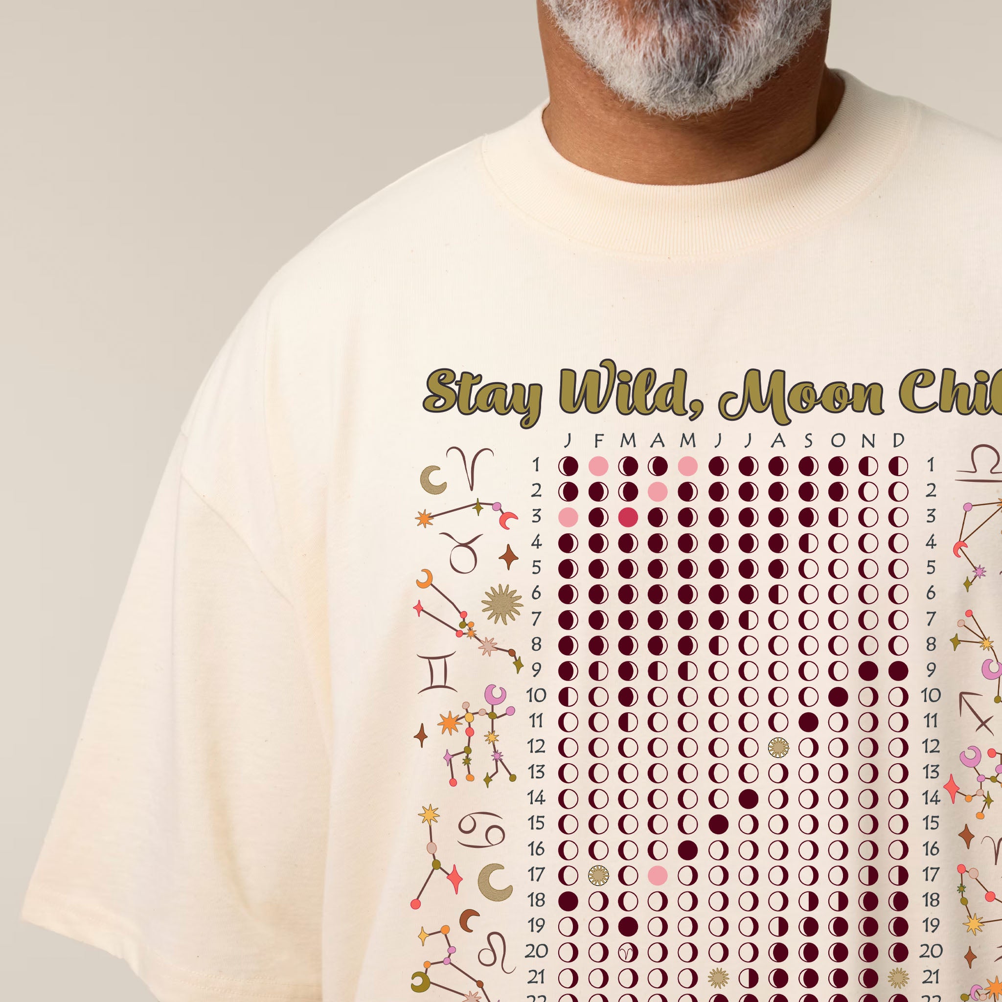 Person wearing a cream t-shirt with celestial design and text